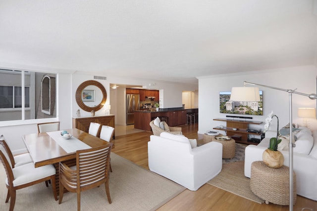 living room with light hardwood / wood-style floors and crown molding