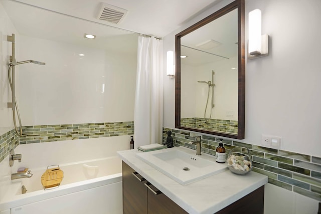 bathroom with decorative backsplash, vanity, and shower / bath combo