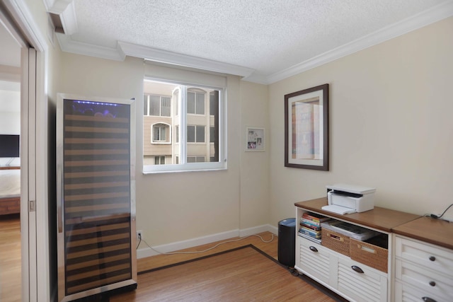 office area featuring ornamental molding, a textured ceiling, beverage cooler, and light hardwood / wood-style flooring