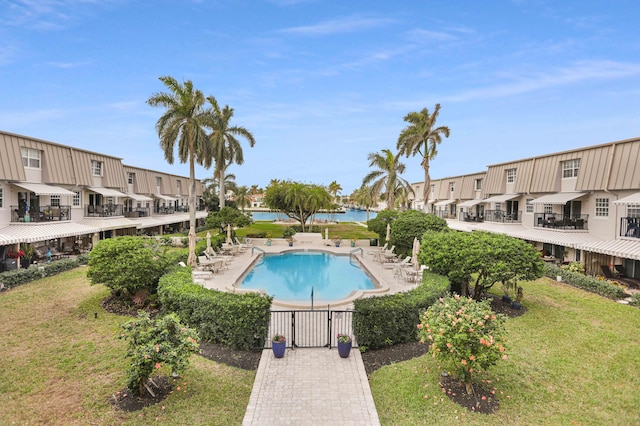 view of pool featuring a lawn and a water view