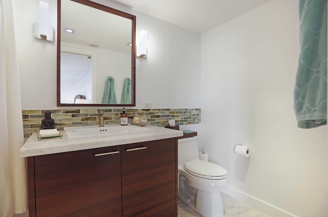 bathroom with tasteful backsplash, vanity, and toilet