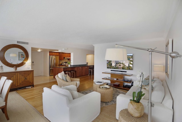 living room with light hardwood / wood-style flooring and crown molding