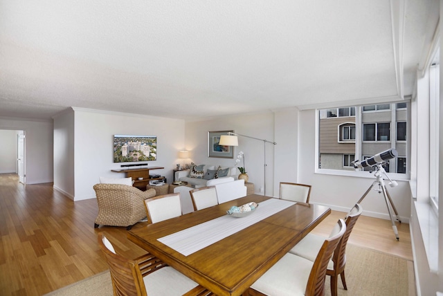 dining space featuring wood-type flooring and a textured ceiling