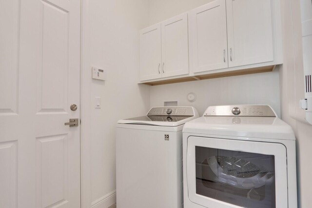 laundry room featuring cabinets and washing machine and clothes dryer