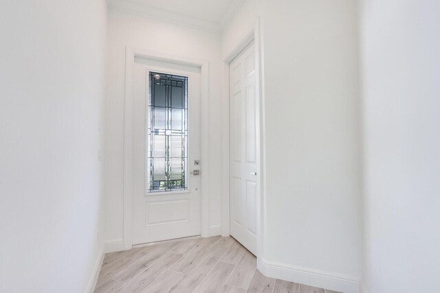 doorway to outside with light hardwood / wood-style floors and ornamental molding