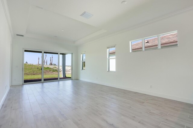 unfurnished room with a tray ceiling and light hardwood / wood-style floors