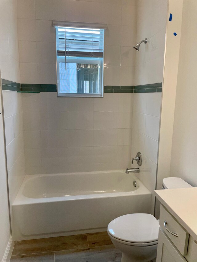 full bathroom with hardwood / wood-style floors, vanity, toilet, and tiled shower / bath combo