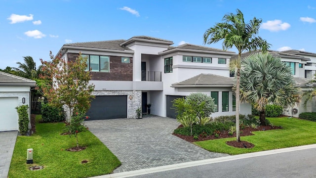 view of front of property with a garage, a balcony, and a front yard