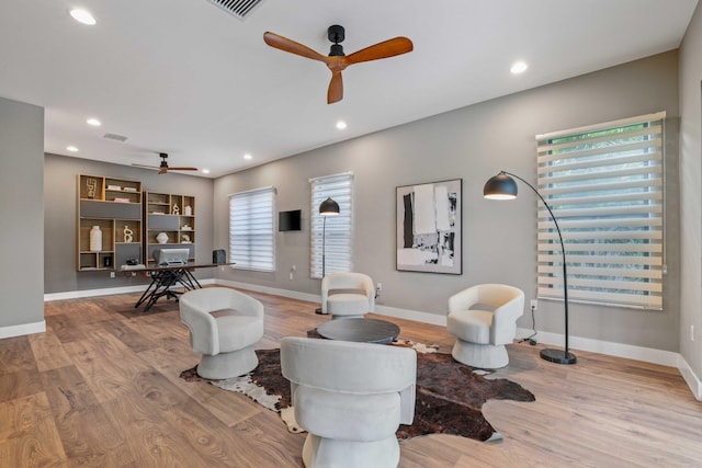 living room featuring light hardwood / wood-style flooring and ceiling fan