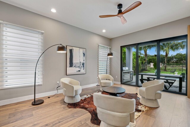 living area featuring ceiling fan, light wood-type flooring, and a wealth of natural light