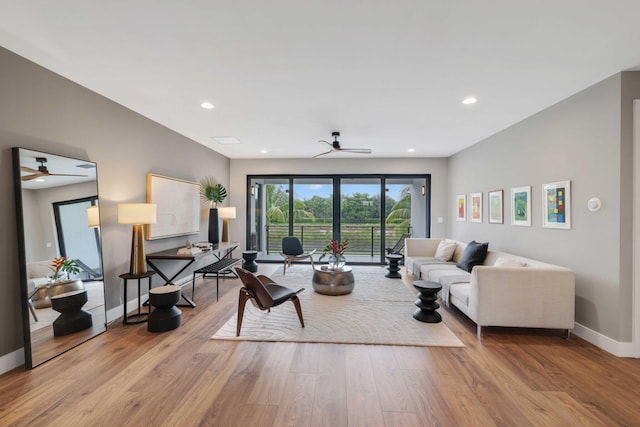 living room featuring ceiling fan and light wood-type flooring