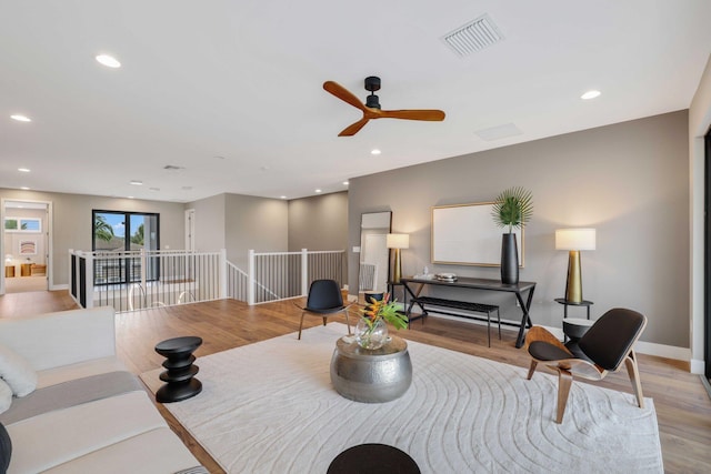 living room featuring light hardwood / wood-style floors and ceiling fan