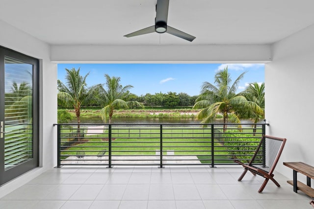 balcony with ceiling fan and a water view