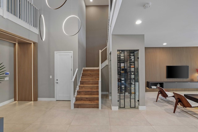 interior space with light tile patterned floors and a towering ceiling