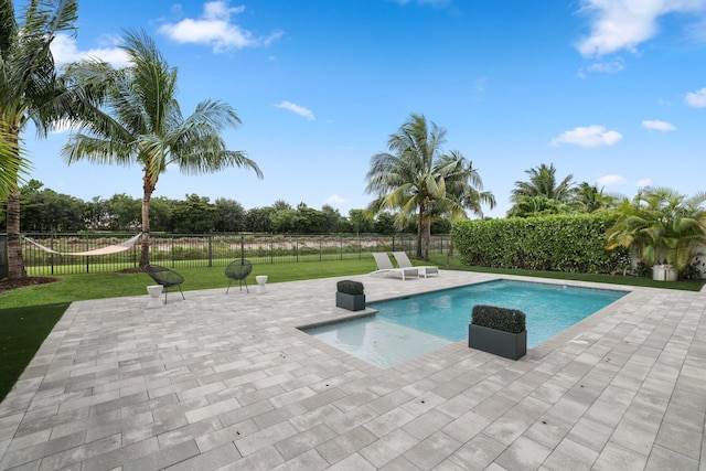 view of swimming pool featuring a yard and a patio