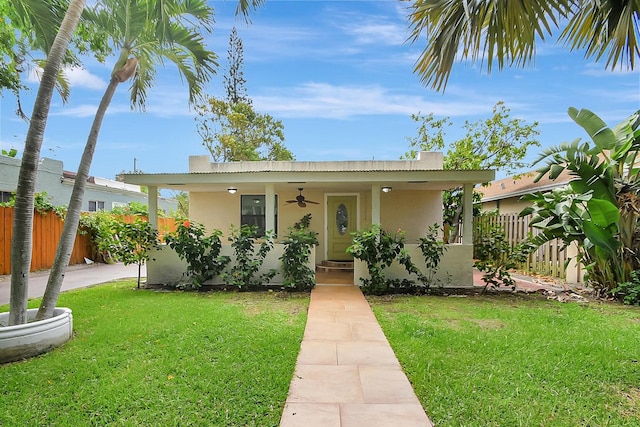 bungalow-style home featuring ceiling fan and a front lawn