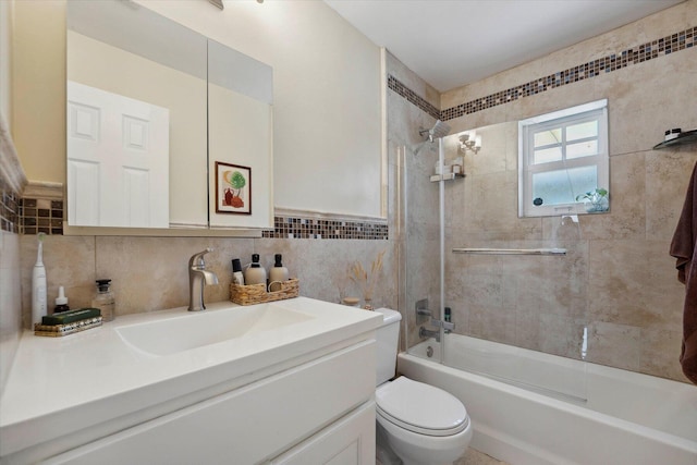 full bathroom with tiled shower / bath combo, vanity, tile walls, and toilet