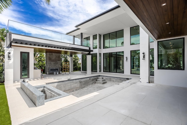 exterior space with an outdoor fireplace and a patio