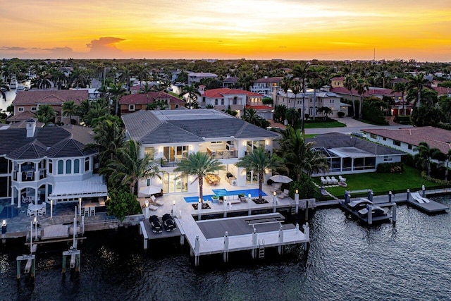 aerial view at dusk featuring a water view