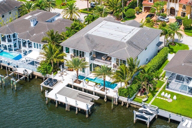 rear view of house with a balcony, a patio, a water view, and french doors