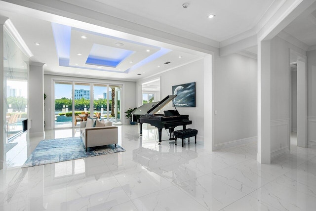 living area with ornamental molding and a tray ceiling