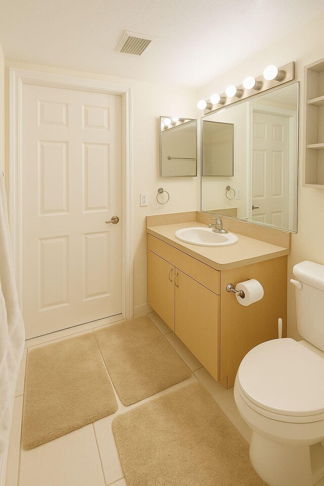 1202 Villa Cir, Boynton Beach, FL 33435 - bathroom featuring vanity, tile patterned floors, and toilet