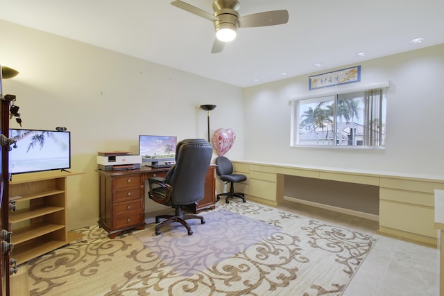 home office with ceiling fan and built in desk