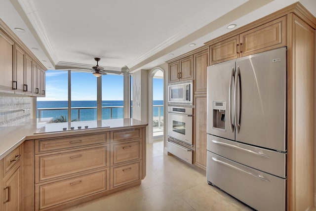 kitchen featuring a water view, ceiling fan, appliances with stainless steel finishes, and crown molding