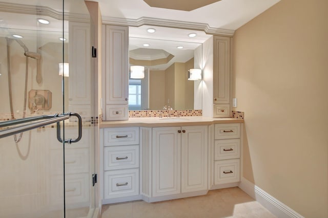 bathroom with backsplash, vanity, a tray ceiling, ornamental molding, and walk in shower