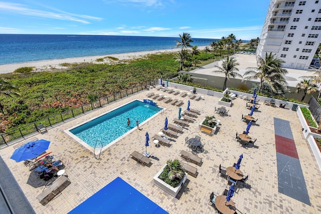 view of swimming pool featuring a water view and a beach view