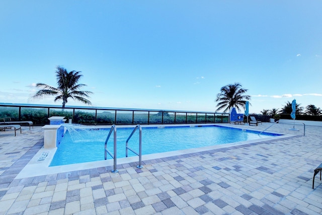 view of swimming pool with pool water feature and a patio area