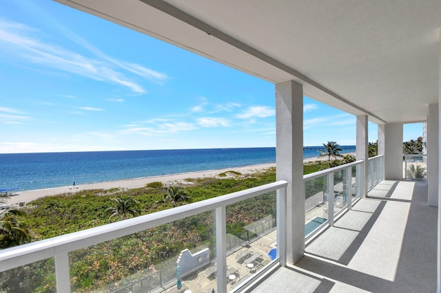 balcony featuring a water view and a beach view