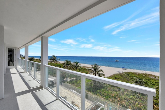 balcony featuring a water view and a beach view