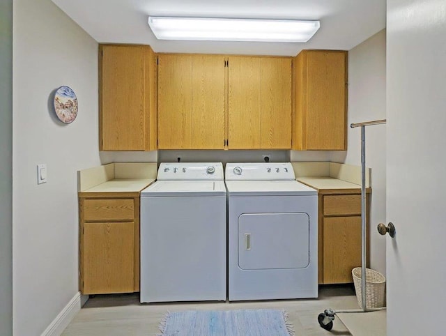 washroom with cabinets and washer and clothes dryer