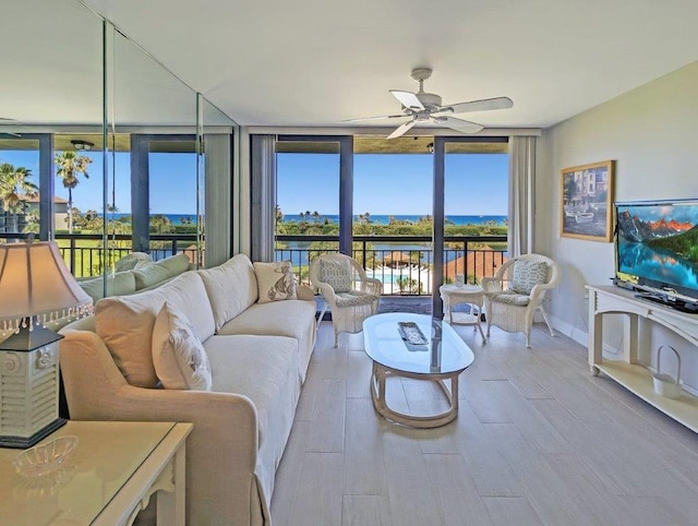 living room featuring expansive windows, ceiling fan, and hardwood / wood-style floors