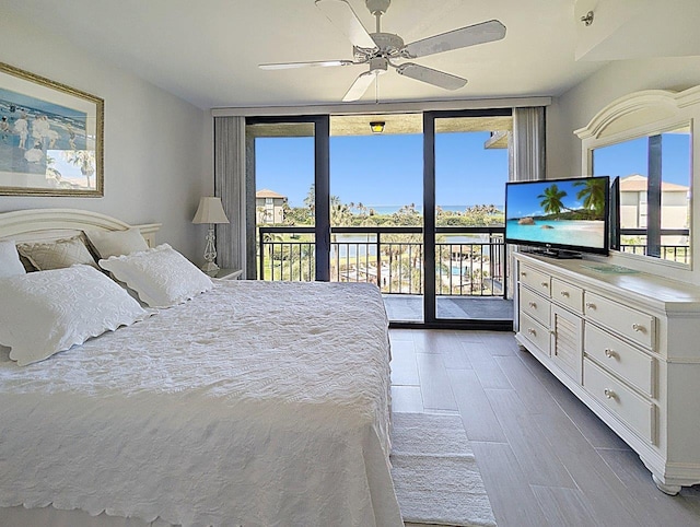 bedroom with expansive windows, ceiling fan, and access to exterior