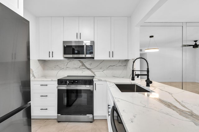 kitchen featuring light stone counters, white cabinetry, sink, and appliances with stainless steel finishes