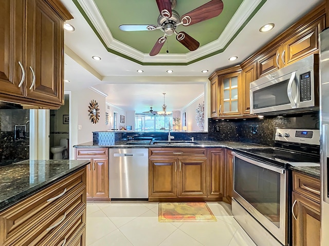 kitchen featuring backsplash, sink, a raised ceiling, and appliances with stainless steel finishes