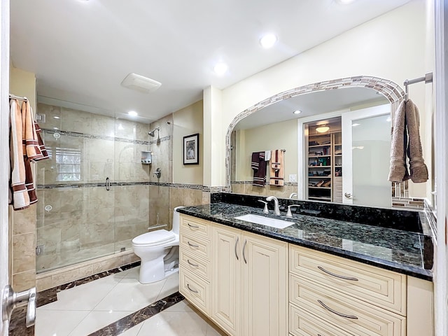 bathroom with tile patterned floors, vanity, toilet, and a shower with shower door