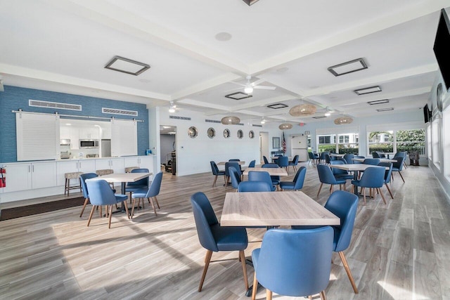 dining space featuring beamed ceiling, light wood-type flooring, ceiling fan, and coffered ceiling