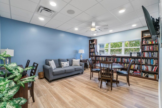 interior space with light wood-type flooring, a drop ceiling, and ceiling fan