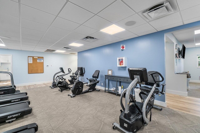 workout area with light carpet and a paneled ceiling