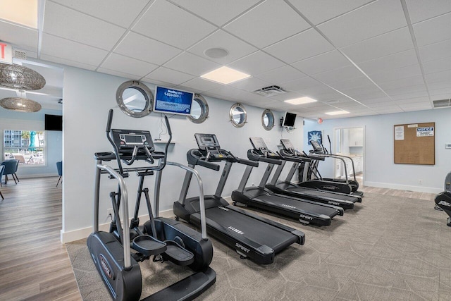 exercise room featuring a paneled ceiling and wood-type flooring