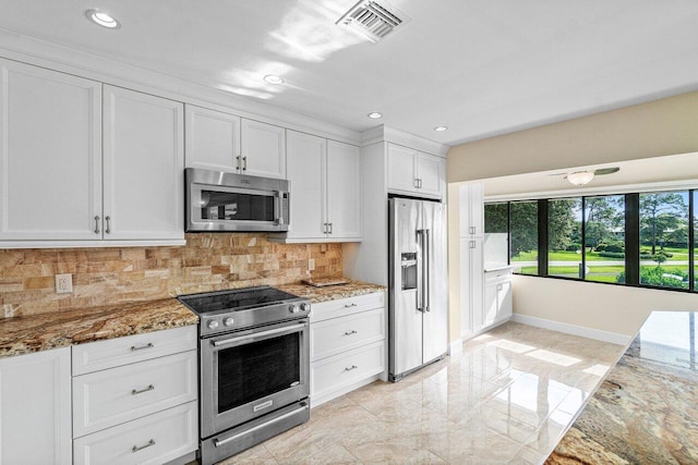 kitchen featuring white cabinets, stainless steel appliances, light stone counters, and tasteful backsplash