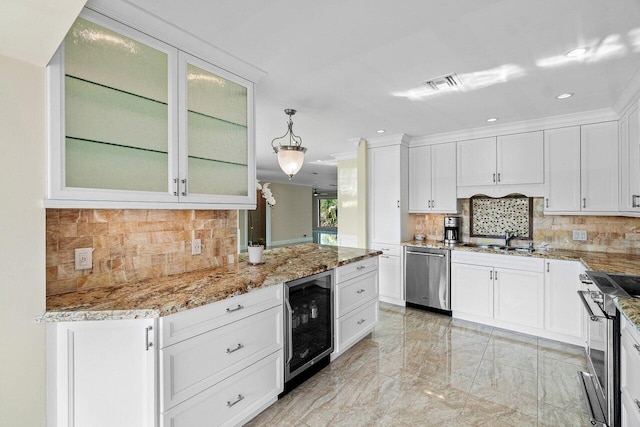 kitchen featuring appliances with stainless steel finishes, pendant lighting, white cabinetry, and beverage cooler