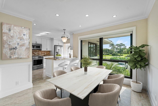 dining room featuring ornamental molding, recessed lighting, wainscoting, a decorative wall, and marble finish floor