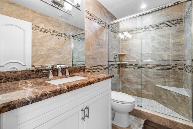 bathroom featuring vanity, an enclosed shower, and toilet