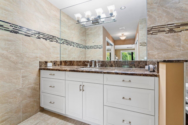 bathroom featuring vanity and tile walls