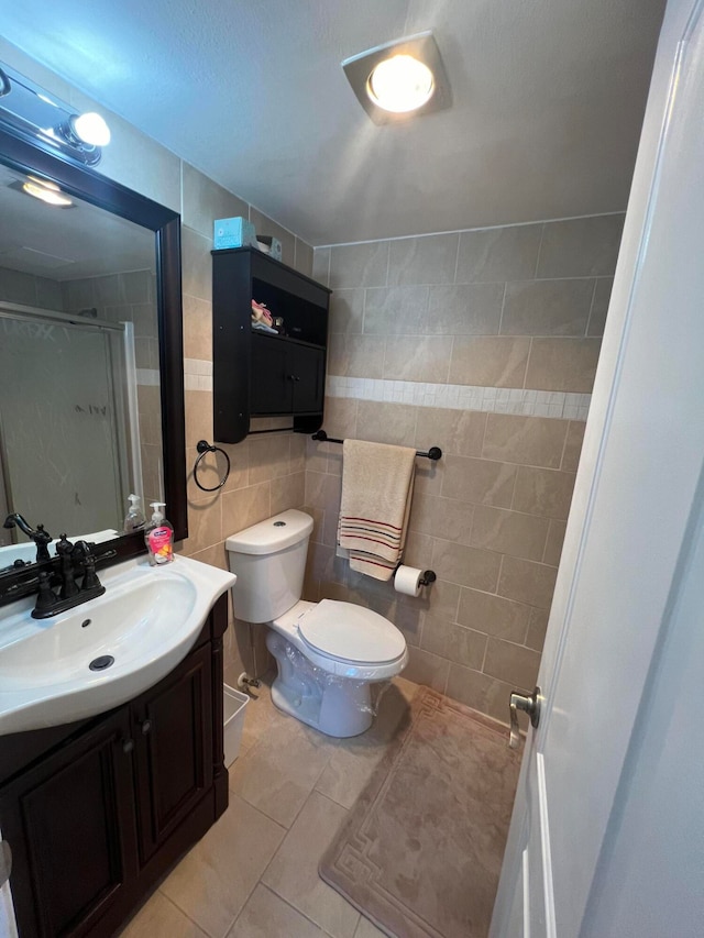 bathroom featuring tile walls, tile floors, vanity, and toilet