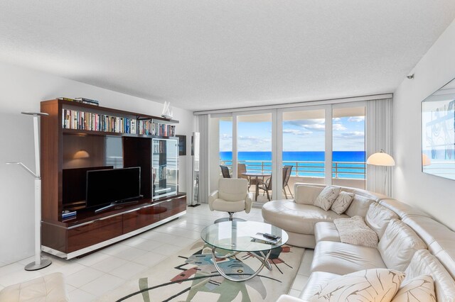 tiled living room featuring a textured ceiling, a healthy amount of sunlight, and floor to ceiling windows